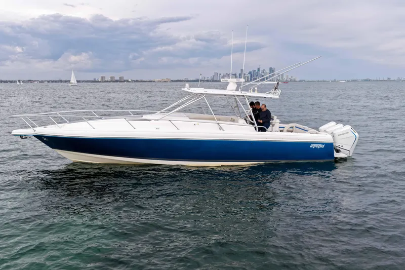 Slide: The Image of 2003 Intrepid 377 Walkaround boat on water with city skyline in background. - 8