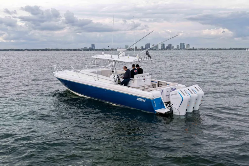 Slide: The Image of 2003 Intrepid 377 Walkaround boat on water with city skyline in background. - 9
