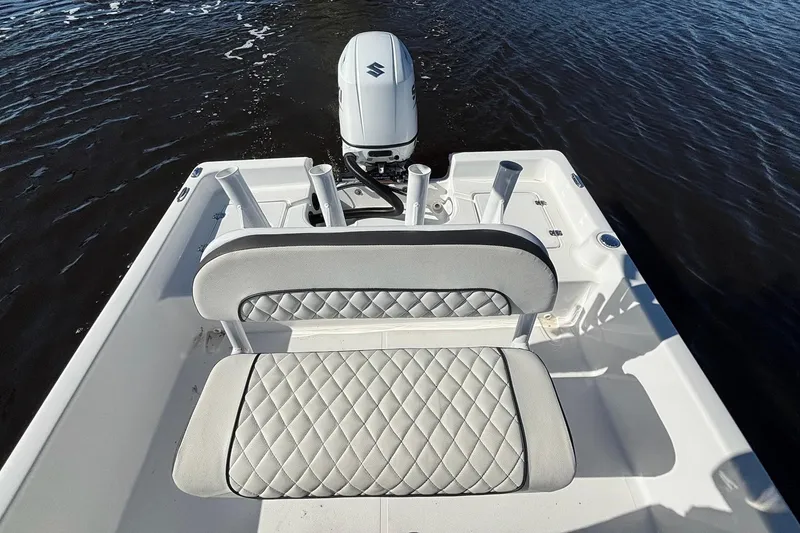 Slide: The Image of 2022 Clearwater 2100 Baystar boat with cushioned seating and outboard motor on water. - 13