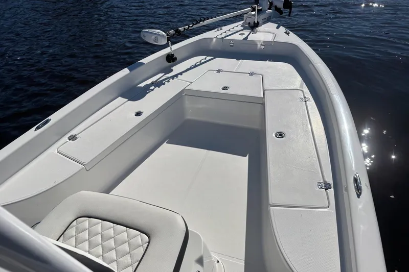 Slide: The Image of 2022 Clearwater 2100 Baystar boat interior with seating and storage on calm water. - 14