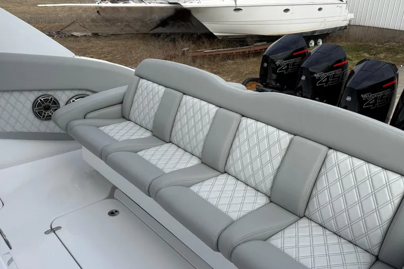 Slide: The Image of Luxurious seating on 2023 Mystic Powerboats M5200 with powerful outboard engines in background. - 13