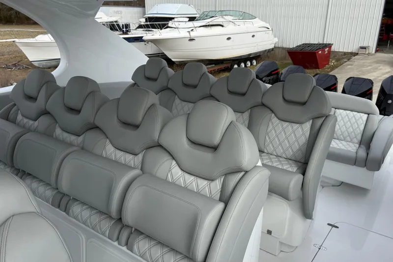 Slide: The Image of Luxurious seating on 2023 Mystic Powerboats M5200, featuring elegant gray upholstery and diamond stitching. - 16