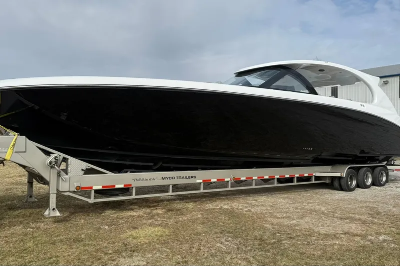 Slide: The Image of 2023 Mystic Powerboats M5200 on trailer, sleek black and white design. - 2