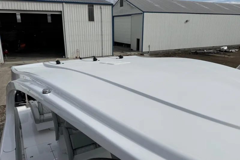 Slide: The Image of 2023 Mystic Powerboats M5200 roof detail near industrial buildings. - 22