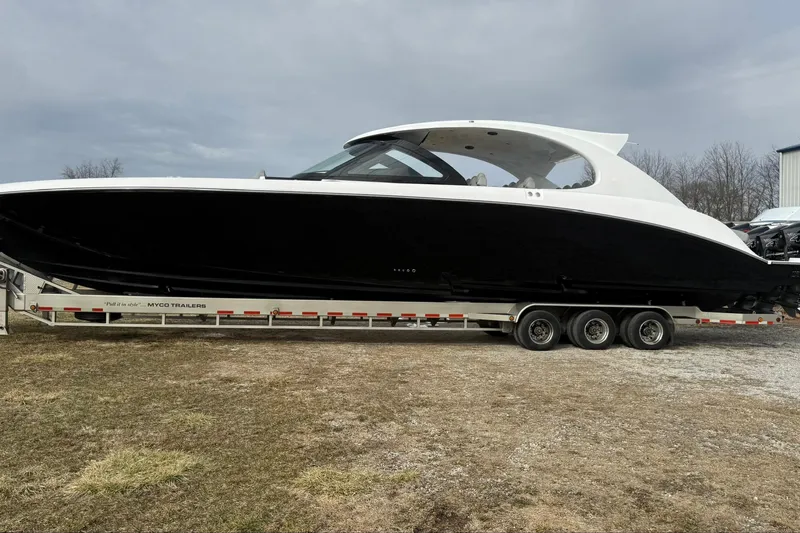 Slide: The Image of 2023 Mystic Powerboats M5200 on trailer, sleek black and white design, parked outdoors. - 3