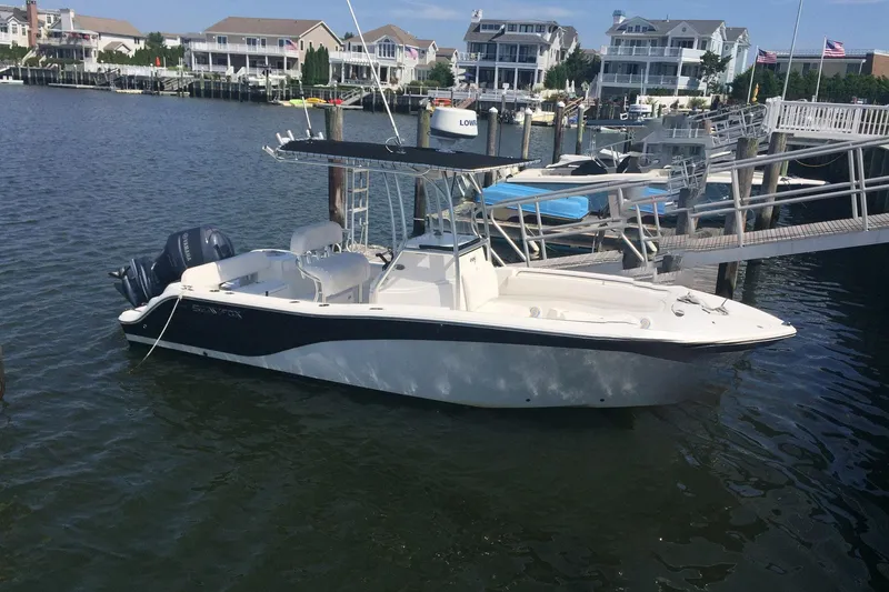 The Image of 2013 Sea Fox 226 Commander boat docked in a marina with waterfront homes. - 1