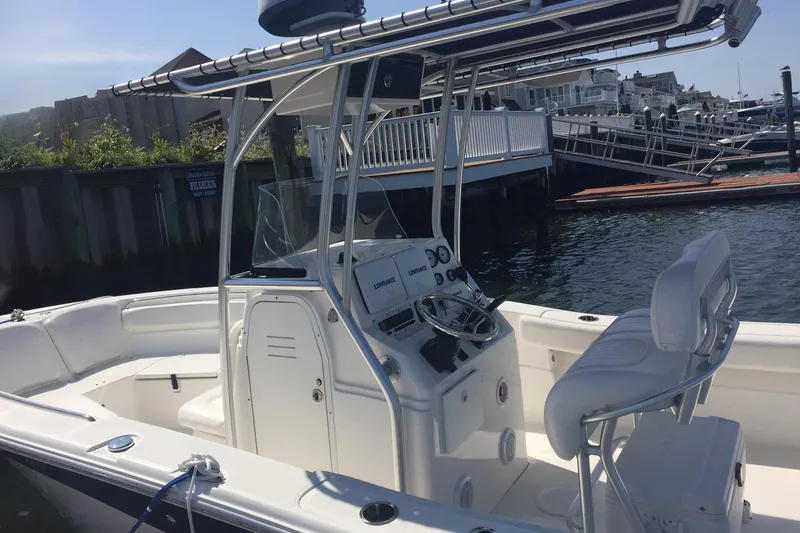 Slide: The Image of 2013 Sea Fox 226 Commander boat docked, featuring helm and seating area. - 4