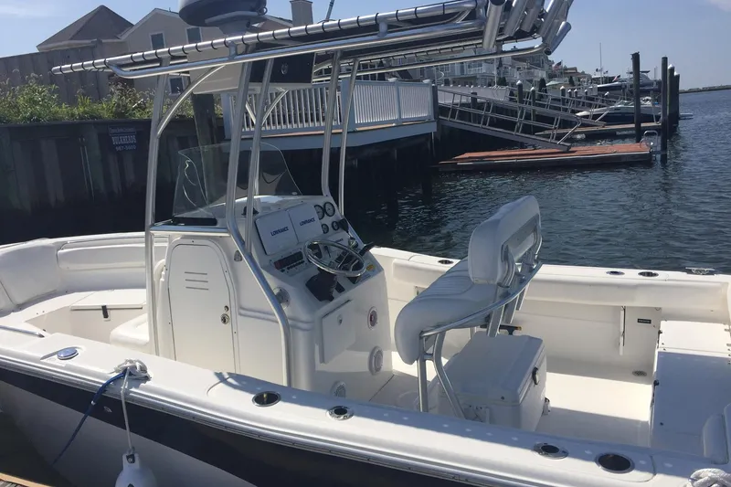 Slide: The Image of 2013 Sea Fox 226 Commander boat docked at marina, featuring center console and seating. - 7