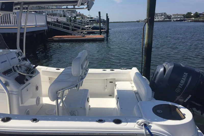 Slide: The Image of 2013 Sea Fox 226 Commander boat docked, featuring Yamaha engine and spacious seating. - 8