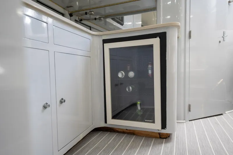 Slide: The Image of Mini fridge in 1997 Strike 42 Express boat interior, with white cabinetry and striped flooring. - 18