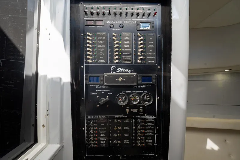 Slide: The Image of Control panel of a 1997 Strike 42 Express boat, featuring various switches and gauges. - 22