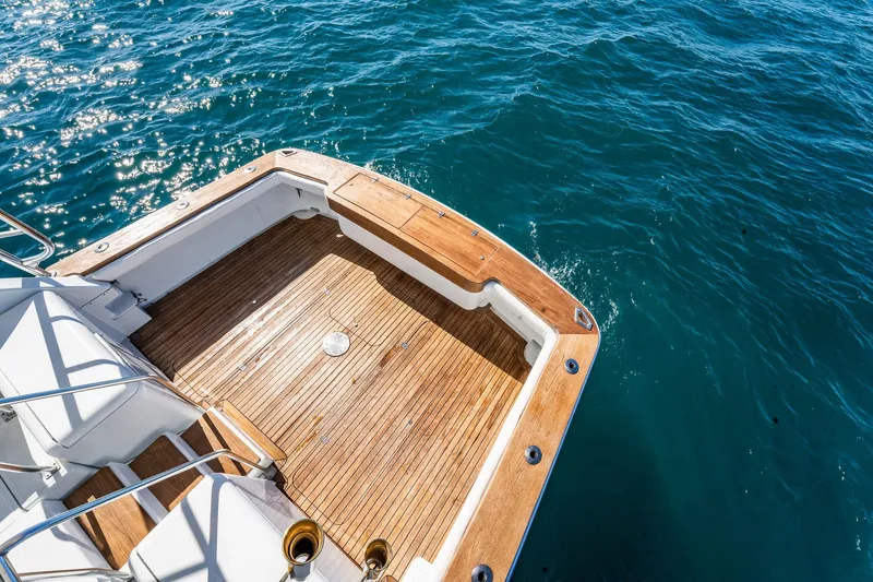 Slide: The Image of 1997 Strike 42 Express boat deck with teak flooring, overlooking sparkling blue ocean water. - 26