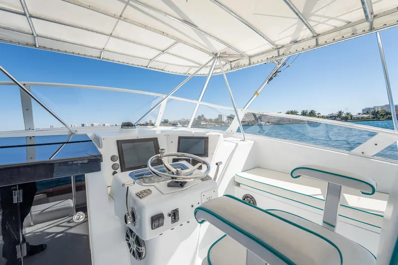 Slide: The Image of Helm of 1997 Strike 42 Express boat with dual screens, steering wheel, and seating. - 31