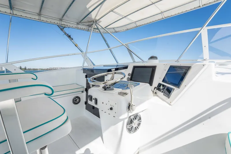 Slide: The Image of 1997 Strike 42 Express boat helm with modern controls and seating under a canopy. - 33