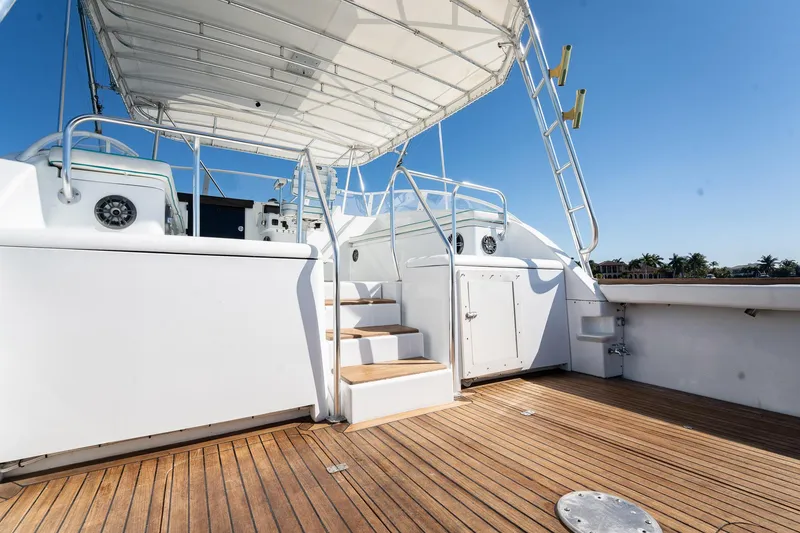 Slide: The Image of 1997 Strike 42 Express yacht deck with wooden flooring and white railings under clear blue sky. - 34