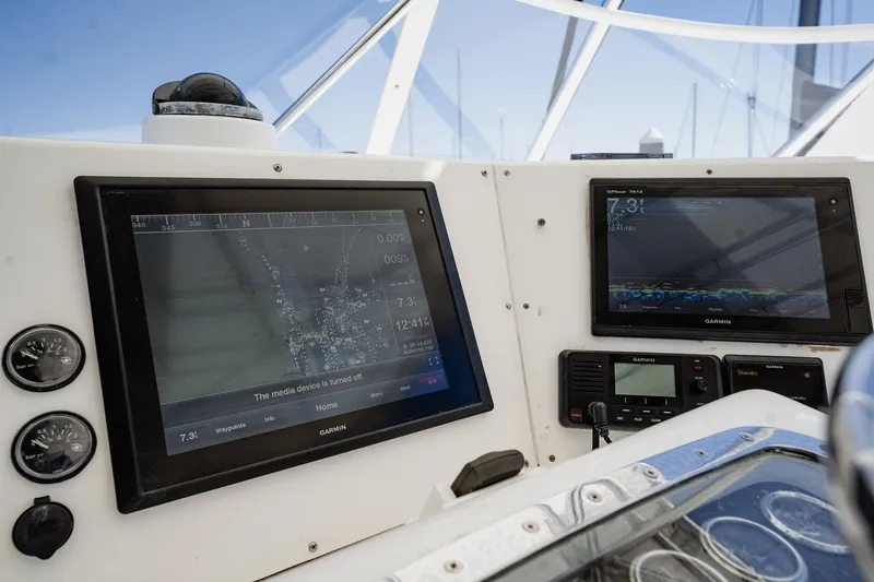 Slide: The Image of Control panel of a 1997 Strike 42 Express boat with Garmin navigation displays. - 37