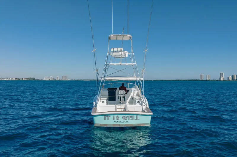 Slide: The Image of 1997 Strike 42 Express boat on open water, clear sky, city skyline in background. - 38