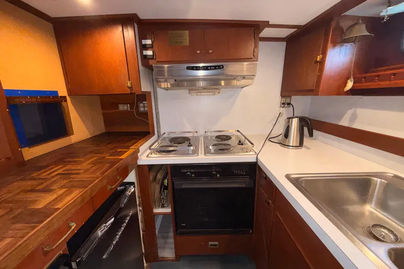 Slide: The Image of Vintage 1965 custom trawler kitchen with wooden cabinetry, stove, and sink. - 11