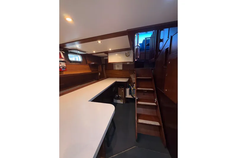 Slide: The Image of Interior of a 1965 custom trawler with wooden stairs and sleek countertops. - 13