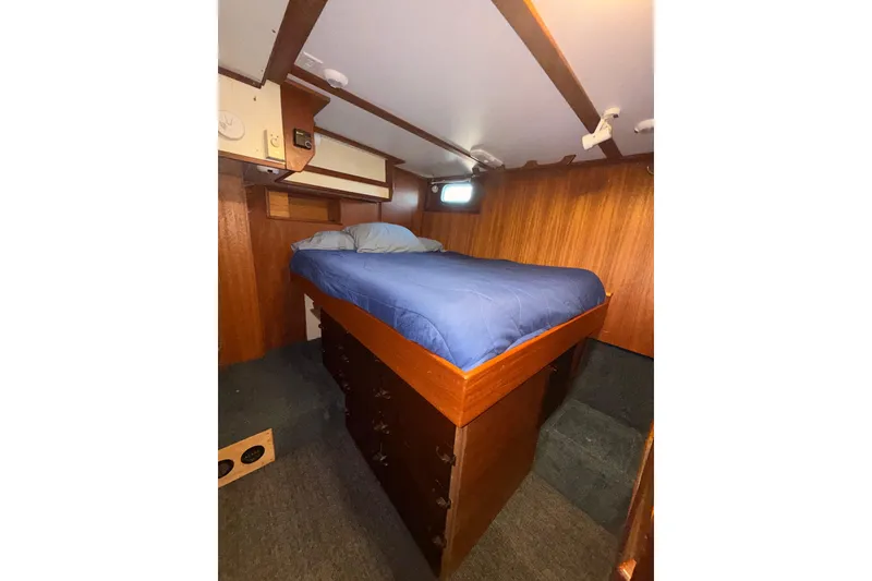 Slide: The Image of Cozy cabin interior of a 1965 Custom Trawler with wooden walls and a blue bedspread. - 17