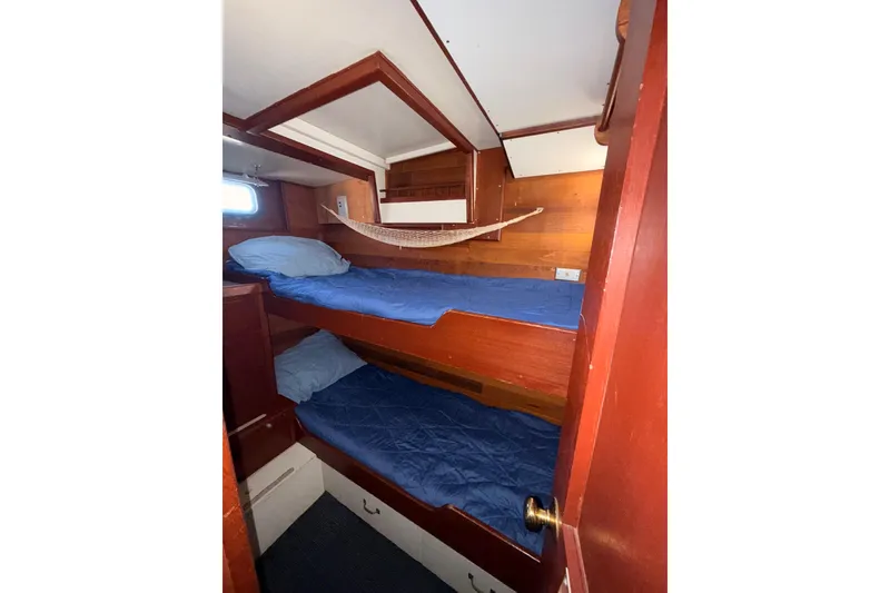 Slide: The Image of Cozy 1965 Custom Trawler cabin with wooden bunk beds and blue bedding. - 19
