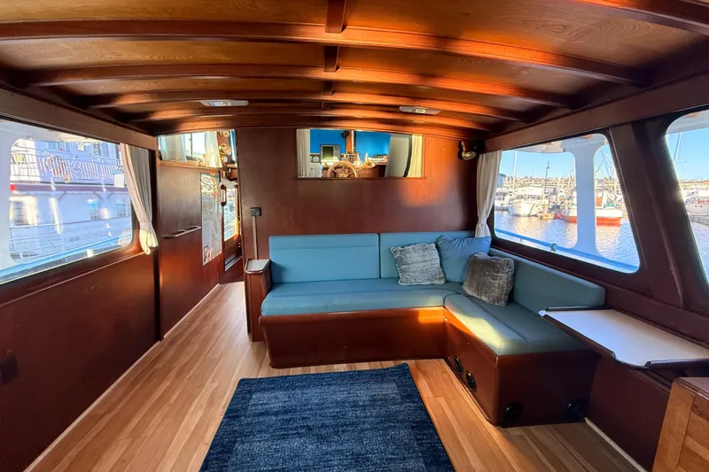 Slide: The Image of Interior of a 1965 custom trawler with wooden paneling and blue seating. - 2