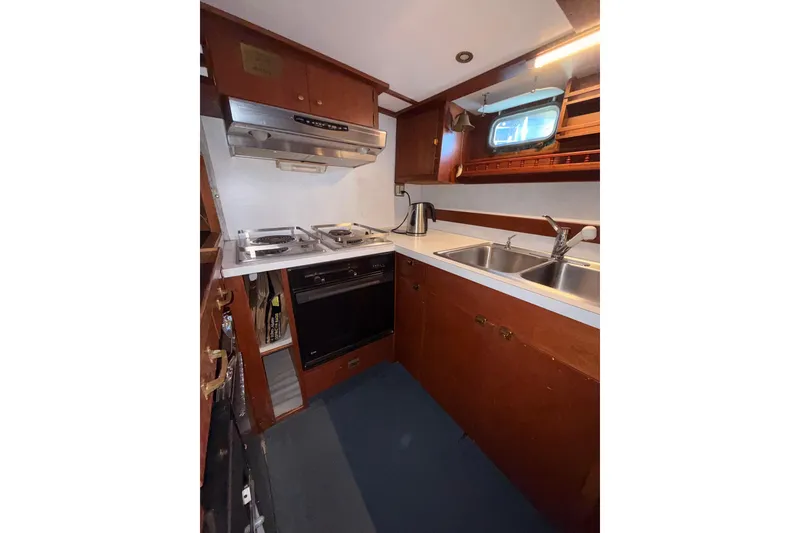 Slide: The Image of 1965 Custom Trawler kitchen with stove, oven, dual sink, and wooden cabinetry. - 20