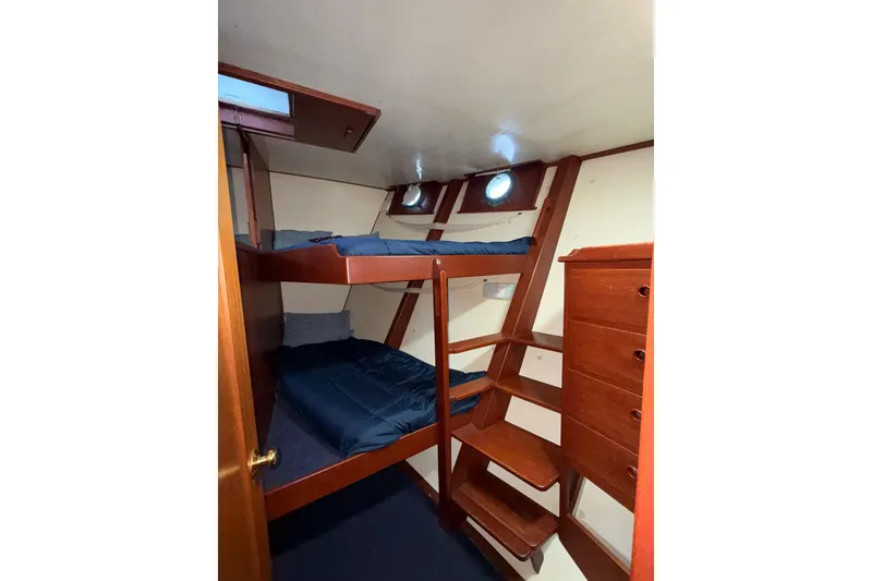 Slide: The Image of Interior of a 1965 Custom Trawler with wooden bunk beds and storage. - 23