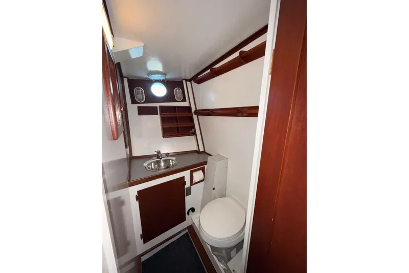Slide: The Image of 1965 Custom Trawler bathroom with sink, toilet, and wooden shelving. - 25