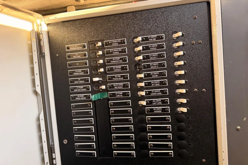 Slide: The Image of Electrical panel on a 1965 Custom Trawler, featuring labeled switches and controls. - 27