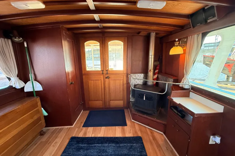 Slide: The Image of Interior of a 1965 Custom Trawler with wood paneling and a cozy stove. - 3