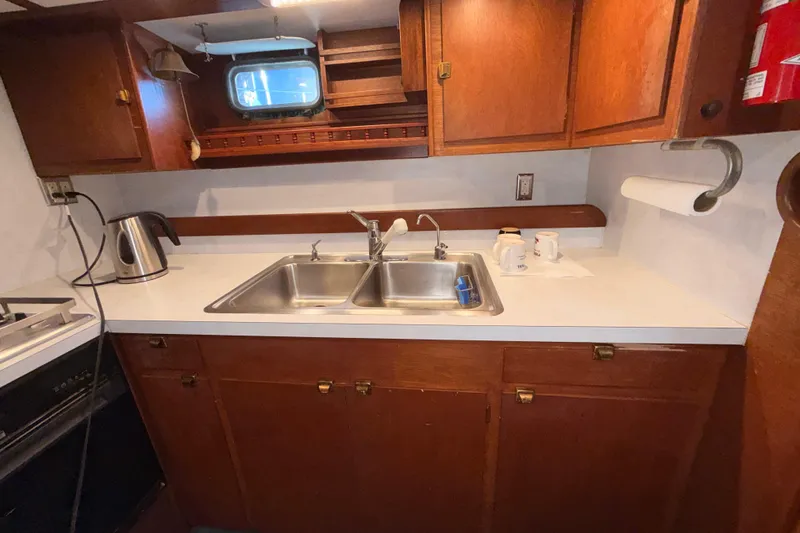 Slide: The Image of Vintage 1965 Custom Trawler kitchen with wooden cabinets and dual sink. - 6