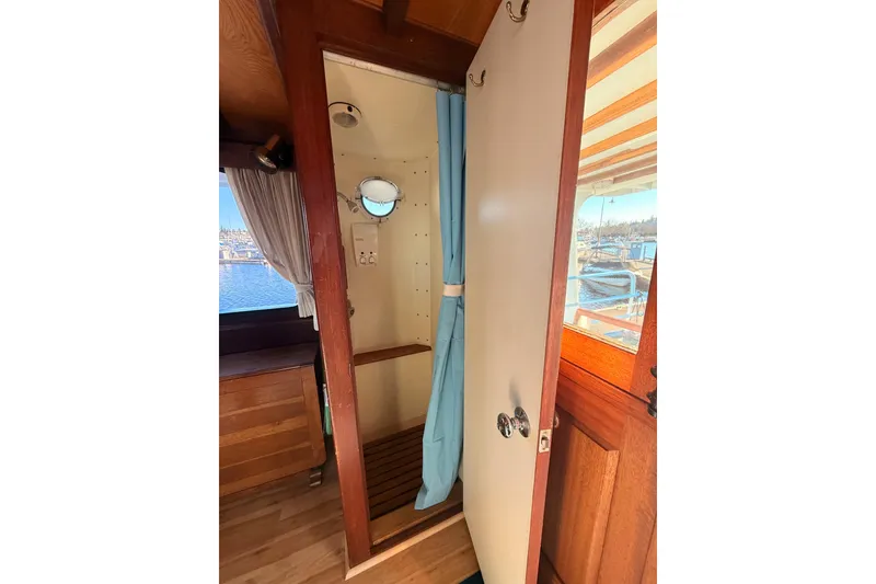 Slide: The Image of Interior of a 1965 Custom Trawler with wooden accents and a small porthole window. - 7
