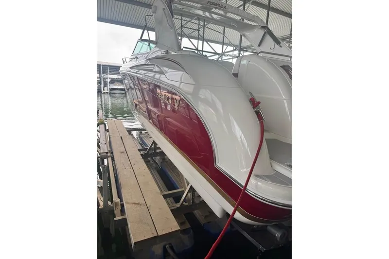Slide: The Image of 2003 Formula 400 Super Sport boat docked in marina, featuring sleek red and white design. - 3
