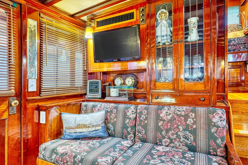 Slide: The Image of Interior of a 1926 Hacker-Craft Bridge Deck with wood furnishings and floral couch. - 14