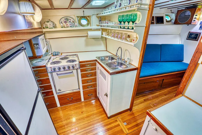 Slide: The Image of Interior of a 1926 Hacker-Craft Bridge Deck yacht with kitchen and seating area. - 21