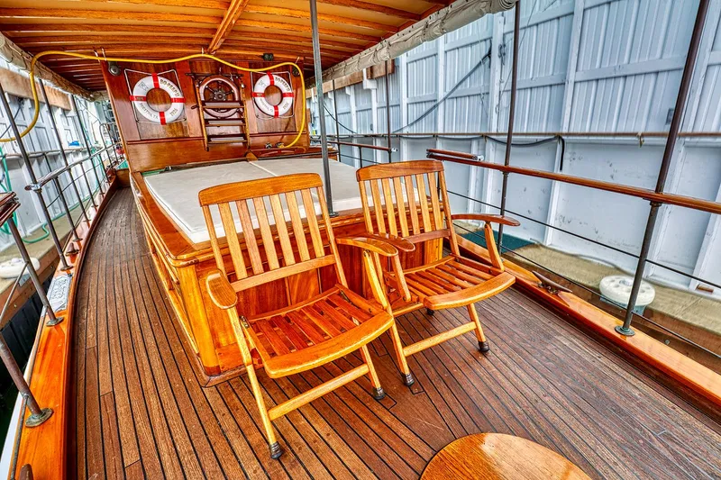 Slide: The Image of 1926 Hacker-Craft Bridge Deck with wooden furniture and lifebuoys. - 6