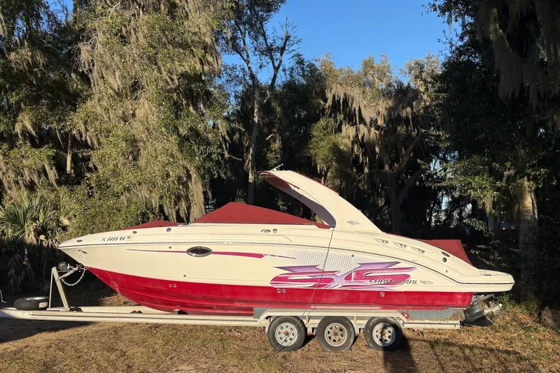 The Image of 2015 Chaparral 287 SSX boat on trailer, parked in a wooded area. - 0
