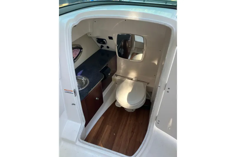 Slide: The Image of 2015 Chaparral 287 SSX boat interior with toilet, sink, and mirror. - 19