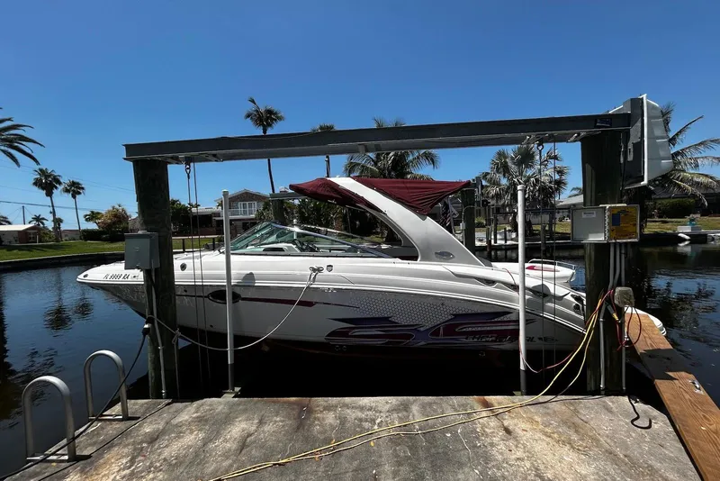 Slide: The Image of 2015 Chaparral 287 SSX boat docked on a lift, surrounded by palm trees. - 5