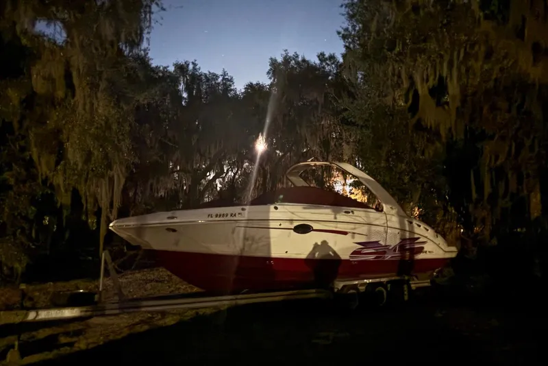 Slide: The Image of 2015 Chaparral 287 SSX boat on trailer, surrounded by trees at night. - 6