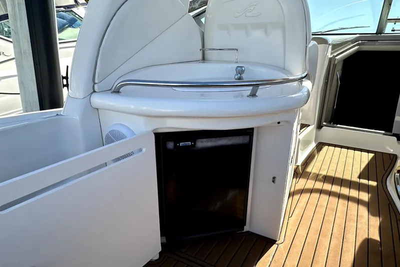Slide: The Image of 2003 Sea Ray 340 Sundancer cockpit with sink and mini fridge on teak flooring. - 11