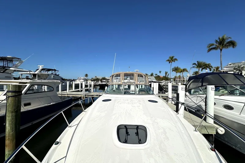 Slide: The Image of 2003 Sea Ray 340 Sundancer yacht docked at marina under clear blue sky. - 13