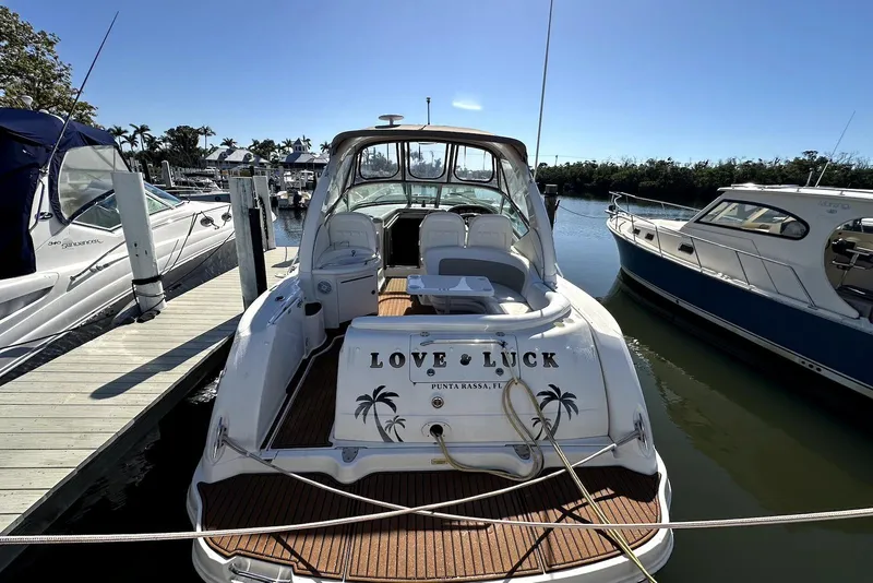 Slide: The Image of 2003 Sea Ray 340 Sundancer docked, rear view with "Love Luck" name visible. - 3
