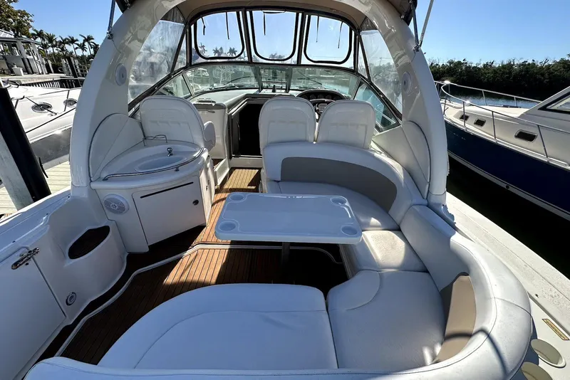 Slide: The Image of 2003 Sea Ray 340 Sundancer interior with white seating and table, docked at marina. - 7