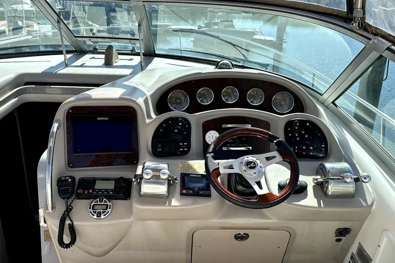 Slide: The Image of 2003 Sea Ray 340 Sundancer helm with steering wheel, gauges, and navigation equipment. - 8