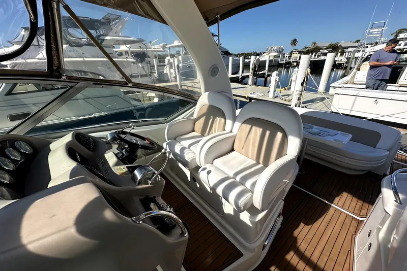 Slide: The Image of 2003 Sea Ray 340 Sundancer cockpit with dual seats and helm, docked at marina. - 9