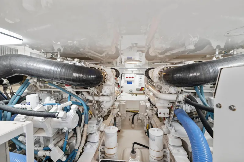 Slide: The Image of Engine room of a 2008 Viking Convertible yacht, showcasing complex machinery and piping. - 35