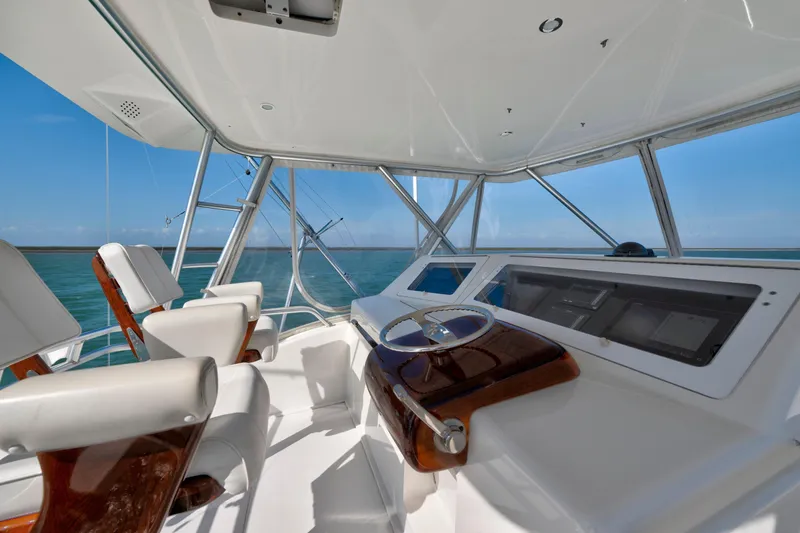 Slide: The Image of 2008 Viking Convertible yacht helm with ocean view, featuring modern controls and seating. - 6