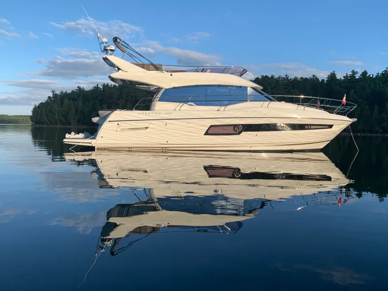 Slide: The Image of 2018 Prestige 460 Yacht on calm water, reflecting surface. - 5